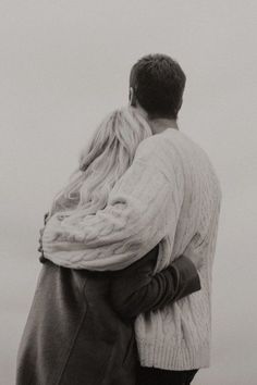 a man and woman embracing each other on the beach