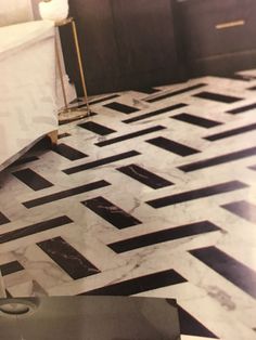 a bathroom with black and white marble flooring, gold accents and a bathtub