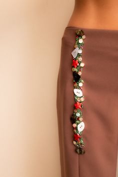 a close up of a woman's skirt with buttons and flowers on the side