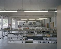 an empty room with lots of shelves and boxes on the floor in front of windows