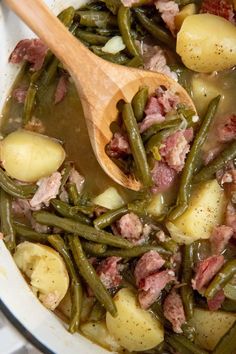 a pot filled with green beans, potatoes and ham