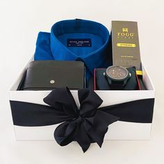 a watch, wallet and other items are in a box with a bow on it