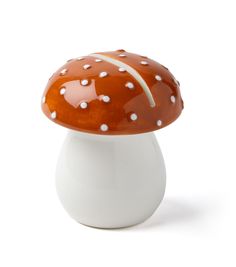 an orange and white mushroom sitting on top of a white vase with dots around it