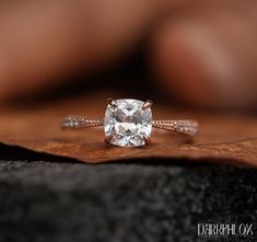 a close up of a diamond ring on a piece of wood