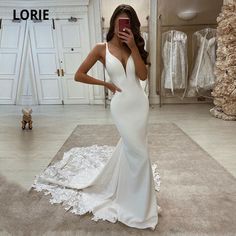 a woman is taking a selfie in her wedding dress while standing on the floor