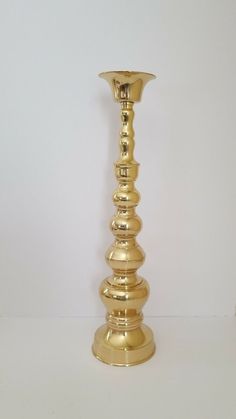 a gold candle holder sitting on top of a white table