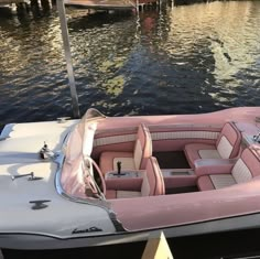 a pink and white boat is docked in the water