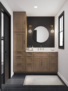 a bathroom with black and white tile flooring and wooden cabinetry, along with a round mirror on the wall