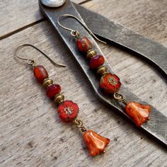 Perfect for fall! The beads on these earrings are all Czech glass beads. They are a mix of oranges. They are shown with antique brass beads and titanium ear wire, but are also available in copper. The bottom bead is 10mm, rustic orange tulip shaped bead. The top bead is a tri-cut orange bead, with a Picasso finish. There is a touch of terra cotta and clear dark red (almost Burgundy) in the 4x7mm bead in the middle. My favorite bead on these is the red orange flower bead. It is an 8mm premium Cze Cut Orange, Rustic Orange, Homemade Stuff, Earring Inspiration, Dangle Earrings Boho, Earrings Wire, Orange Earrings, Brass Beads, Bag Tutorial