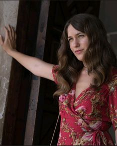 a woman in a red dress is holding her arm out and looking at the camera