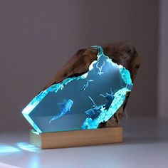 a piece of art that looks like a rock with blue light coming out of it