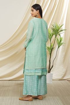 Mint green chanderi kurta with badla embroidery, gota work borders and notched round neck. Paired with pant in floral pattern screen print and dupatta.
Component: 3
Pattern: Printed and Embroidered
Type Of Work: Screen Print, Badla and Gota Work
Neckline: Notched Round Neck
Sleeve Type: Three Quarter Sleeves
Fabric: Chanderi
Color: Blue
Other Details: 
Floral print
Printed dupatta
Panelled border on kurta
Side slits on kurta
Occasion: Mehendi and Haldi,Sangeet - Aza Fashions Badla Embroidery, Kurta Pant Set, Gota Work, Printed Dupatta, Straight Kurta, Kurta With Pants, Pant Set, Printed Pants, Set For Women