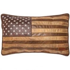 an american flag pillow is shown in brown and gold leather with white stars on it