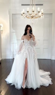 a woman is taking a selfie in her wedding dress while holding a cell phone