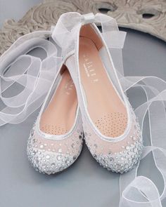 pair of white wedding shoes with veil on table