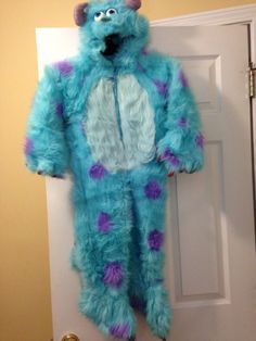 a blue monster costume hanging on the door