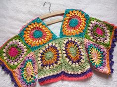 three crocheted squares are on a hanger, one is multicolored