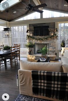 a living room filled with furniture and a flat screen tv mounted to the wall above a fireplace