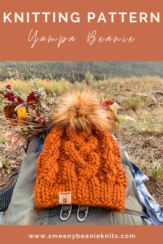 an orange knitted hat sitting on top of a backpack