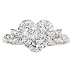 a heart shaped diamond ring with leaves around it