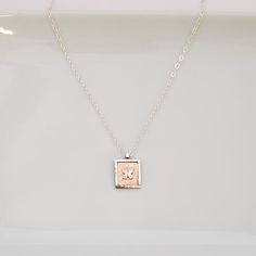 A touch of joy with this artfully designed necklace that is so perfect for gifting and every day wear. *  Hand-fabricated copper square edged with raised sterling silver, featuring tiny sterling silver butterfly set on top *  Sterling silver chain approx. 18"L with 1" extender, lobster clasp *  Pendant approx. 5/8"W x 3/4"L *  Made one at a time *  Due to the handmade nature of each piece, colors may vary slightly from photo. TURN AROUND TIME *  All of our jewelry pieces are made to order, and our turn around time is approximately 6-10 days.  If you need a rush order, please contact us to see if we can meet your deadline GIFTS - WE LOVE SENDING THEM FOR YOU! *  All jewelry pieces are nicely packaged in jewelry boxes with ribbon or tulle and ready to gift.  Prices are not included in the sh Dainty Hand Stamped Necklace For Mom, Delicate Hand Stamped Necklace For Gift, Small Minimalist Necklace As A Gift, Small Minimalist Necklace For Gift, Minimalist Small Necklace Perfect For Gifts, Small Minimalist Necklace Perfect For Gifts, Rose Gold Necklace Gift For Mom, Nickel-free Rose Gold Necklace For Mom, Personalized Square Pendant Necklace As Gift