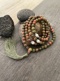 This stylish long beaded necklace is a Mala bead necklace, made with Unakite beads, white beads, small shiny beads and a earth green tassel hanging at the bottom. A Mala necklace that will keep you in style and grounded at the same time. Use it as a necklace, for meditating, as a bracelet, or a decor item. The necklace drop length is The tassel is... A most have addition to your Mala collection. ⚡️Join Akashi's VIP list for early bird discount access⚡️ Paste into your browser http://eepurl.com/h Bohemian 8mm Beads For Jewelry Making, 8mm Bohemian Beads For Jewelry Making, Bohemian Beaded Necklaces With 8mm Beads For Jewelry Making, Bohemian Round Beads For Jewelry Making, Earthy Beaded Necklace With 108 Beads For Healing, Hand-strung Lariat Beads For Gift, Lariat Necklace With 108 Beads For Meditation, Bohemian Beaded Mala, Hand-strung Lariat Beads As A Gift