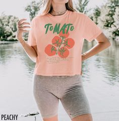 Embrace retro vibes with this vintage-inspired crop top featuring a bold, oversized tomato graphic. Perfect for those who love a pop of color and a touch of nostalgia, this shirt adds a playful twist to any casual outfit. The text at the bottom says, "You say tomato we say pomodoro, let's call the whole thing off and explore the delicious ways to eat the juicy sun ripened fruit" We use professional quality DGT printing on all our apparel. Direct-to-garment, or DTG, is a high quality printing met Vintage Cropped T-shirt With Graphic Print For Summer, Retro Summer Crop Top With Letter Print, Retro Letter Print Crop Top For Summer, Retro Cropped T-shirt With Letter Print For Spring, Retro Cotton Crop Top With Relaxed Fit, Retro Cotton Cropped T-shirt For Summer, Vintage Cropped T-shirt With Relaxed Fit For Summer, Vintage Relaxed Fit Cropped T-shirt For Summer, Summer Retro Graphic Print Crop Top