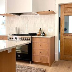 a stove top oven sitting inside of a kitchen next to a wooden cabinet and counter