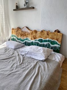 a bed with white linens and wooden headboard on top of it in front of a window