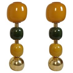 two yellow and green glass lamps sitting on top of each other