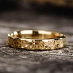 a gold wedding ring sitting on top of a wooden table