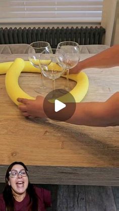 a woman standing in front of a table with wine glasses on it and a banana