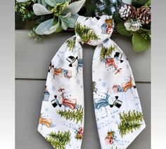 a white scarf with snowmen and trees on it, tied to a planter