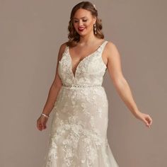 a woman in a wedding dress posing for the camera with her hand on her hip