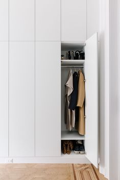 an open closet with shoes and coats