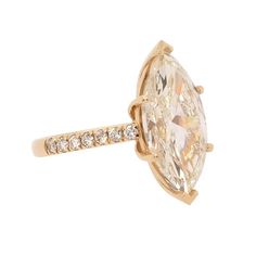 a yellow gold ring with an oval cut diamond in the center and side stones on each band