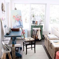 a living room filled with lots of furniture and paintings on the wall next to windows