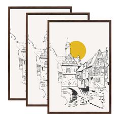 three framed art prints featuring buildings and the sun