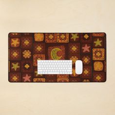 a computer mouse and keyboard on top of a brown mat covered in small squares with flowers