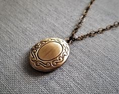 "Lovely photo locket necklace features a small antique brass locket in oval shape. Locket pendant hang on fancy brass chain. Great for wearing alone or layering with other necklace Locket size: 1\" (including loop) X 0.7\" Purchase over $40 enjoys free shipping! Coupon code 'freeshipping1'. Free Gift Wrapping on request - All items that are gift wrapped come in with a kraft box with raffia string and blank writing card. Please leave a note if you need it upon ordering." Bronze Engraved Medallion Necklace As Gift, Elegant Medallion Locket Necklace With Antique Finish, Classic Vintage Charm Brass Necklace, Antique Gold Round Pendant Medallion Necklace, Antique Gold Brass Medallion Necklace, Heirloom Oval Link Locket Necklace, Elegant Antique Finish Round Pendant Locket Necklace, Elegant Antique Finish Round Locket Necklace, Elegant Oval Pendant Locket Necklace For Vintage Collection