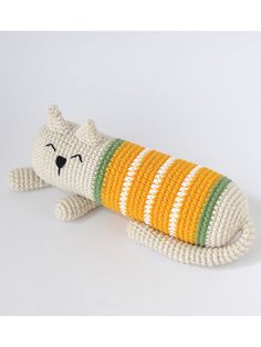 a knitted toy cat laying on its side