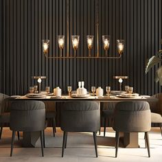 an elegant dining room with black walls and wooden flooring is lit by candle lights