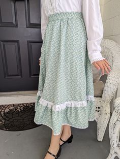 "Ladies small size skirt, made from a vintage Gunne Sax Pattern.  This is a perfect skirt to twirl in ! Plus it has pockets!  Pattern is Simplicity # 5491, from 1982.  Fits a 25\" waist.  Skirt length is 28\". Lying flat, skirt measures : Waist- 13\", Bottom of Ruffle 47\".  Fabric is cotton, green floral.   Has a ruffled edge with lace and  ribbon trim. bottom lace on ruffle is vintage.  Two side pockets, zipper, and a vintage button on waistband." Vintage Green Tiered Skirt, Fitted Full Skirt In Cottagecore Style, Cottagecore Full Skirt Fitted At Waist, Fitted Cottagecore Full Skirt, Cottagecore Full Skirt With Fitted Waist, Cottagecore Fitted Full Skirt, Cottagecore Gathered Flowy Skirt, Cottagecore Long Skirt With Ruffles, Cottagecore Flowy Gathered Skirt