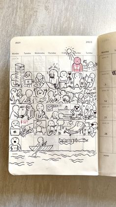 an open notebook with cartoon drawings on the pages and in front of it is a calendar