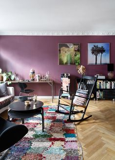 a living room with purple walls and wooden floors