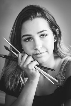 black and white photograph of a woman holding three pencils