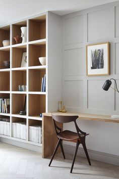 a chair sitting in front of a book shelf filled with books