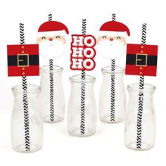 three glass vases with santa's hats on them, one has a straw in it and the other is empty