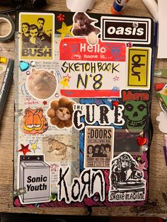 an assortment of stickers and decals on a wooden table with pens, scissors, markers, and other items