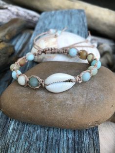 "Sea lover's Bracelet! You can almost here the waves crash when you gaze at these beautiful bracelets. The single Cowrie shell is surrounded in lovely coastal colored 6mm matte Amazonite stones. Shown carefully knotted onto natural cotton cord, grey polyester waterproof cord and grey cotton cord with seed beads in coordinating colors on the closure strings. My bracelets are made to order especially for you so please allow me artistic freedom in creating your own unique bracelet:) I hope this bra Beach Bracelet, Lovers Bracelet, Beautiful Bracelets, Sea Lover, Beach Bracelets, Amazonite Stone, Aesthetic Board, Shell Bracelet, Diffuser Bracelets